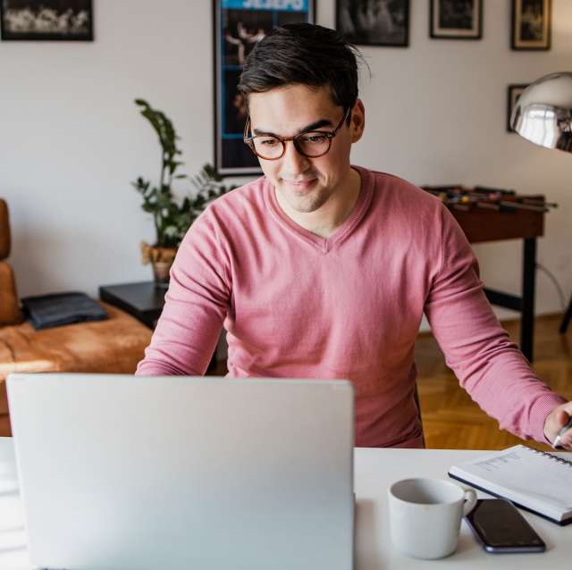 mann-laptop-notizbuch-wohnzimmer